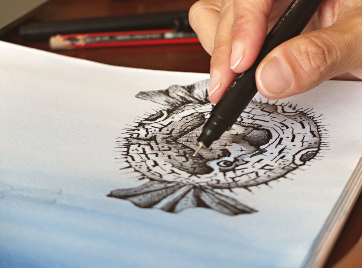 Close-up of a hand using a black fineliner pen to fill in a monochrome coloring page, varying densities of pattern visible, creating natural contrast with just black ink, warm desk lighting, focused and peaceful mood
