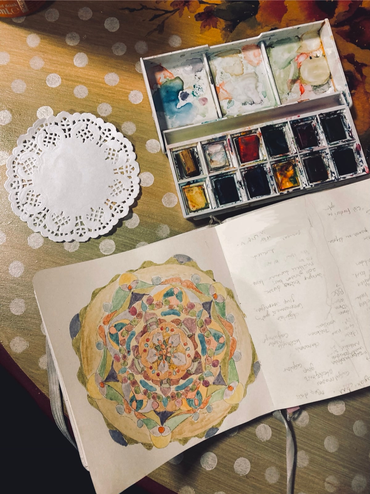 Finished mandala coloring page with vibrant symmetrical colors radiating from the center in a kaleidoscope pattern, colored pencils arranged nearby by color family, satisfying and complete artwork, warm soft lighting, flat lay photography