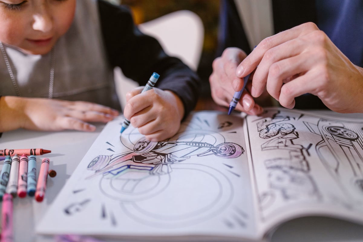 photograph of hands carefully coloring in a structured detailed pattern for focus