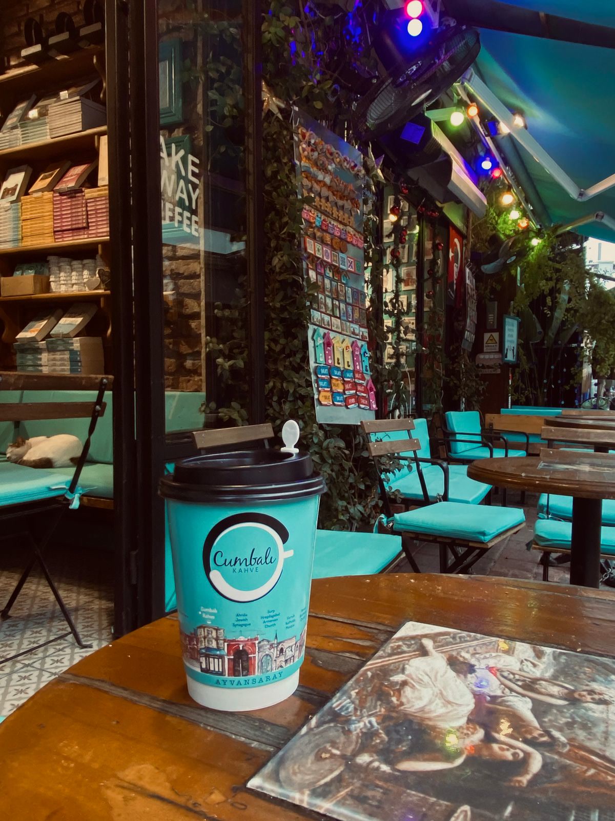 Cozy outdoor cafe scene with coffee and a book on a wooden table