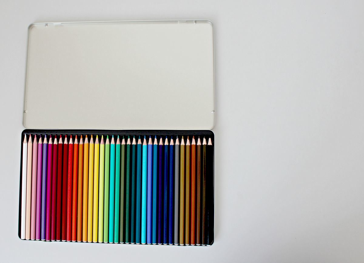Assorted colored pencils arranged in an open box, vibrant colors ready for use