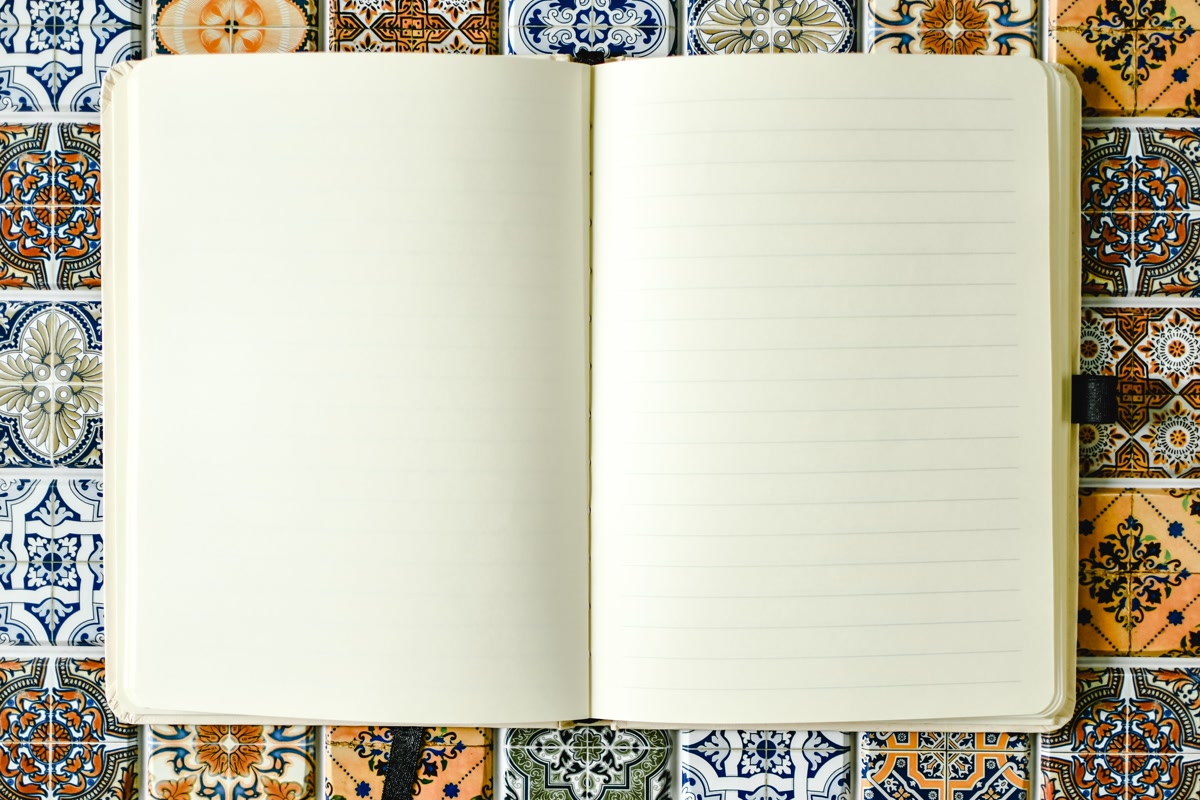 Open journal next to a finished coloring page with colored pencils