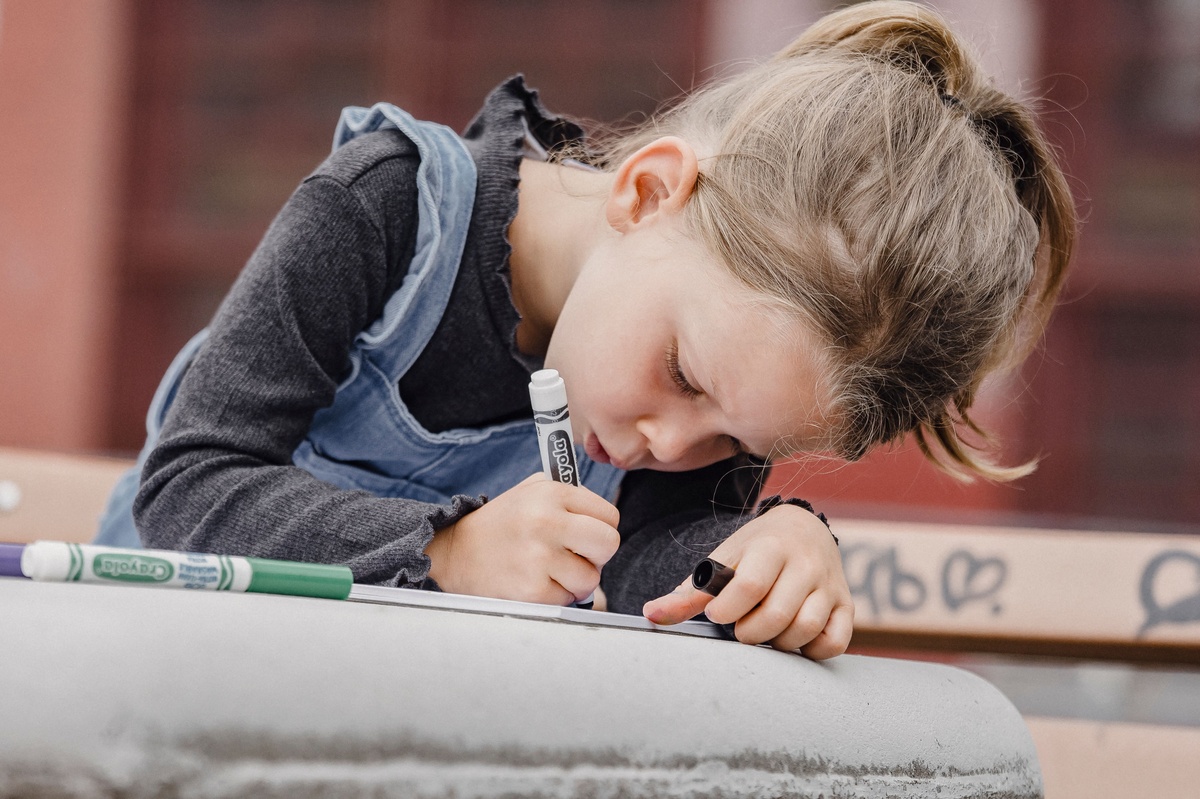 A completed coloring page colored entirely with Crayola markers showing vibrant smooth results, markers displayed alongside, satisfying and accomplished feel, flat lay photography