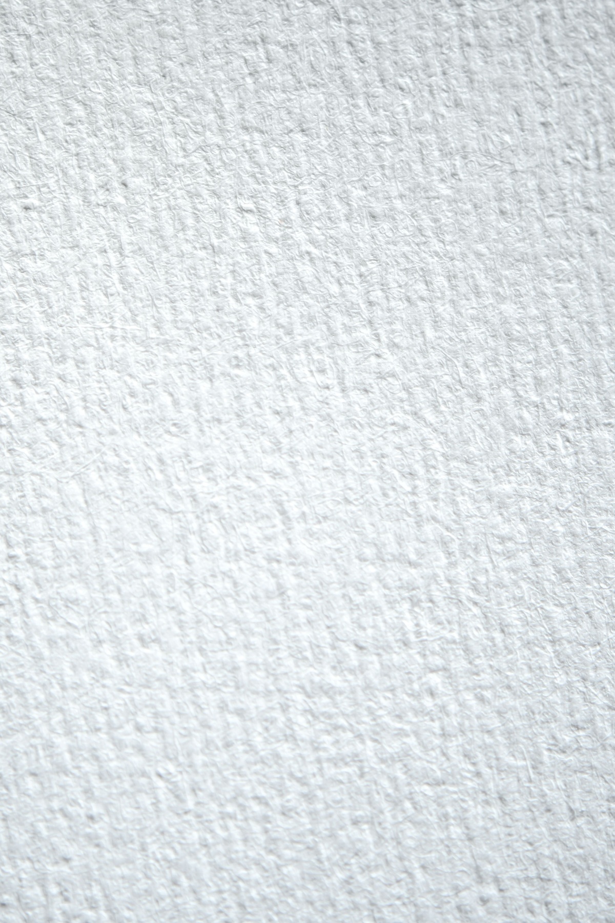 Side by side comparison of smooth white paper and toothy cream paper with colored pencil strokes, showing the difference in pigment grip and texture, macro photography