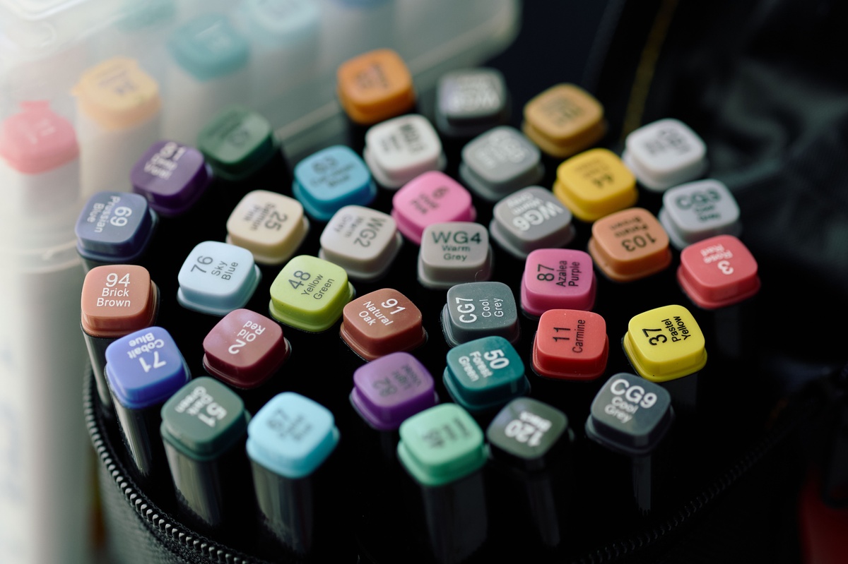 Markers arranged in an organized flat lay with pen caps visible