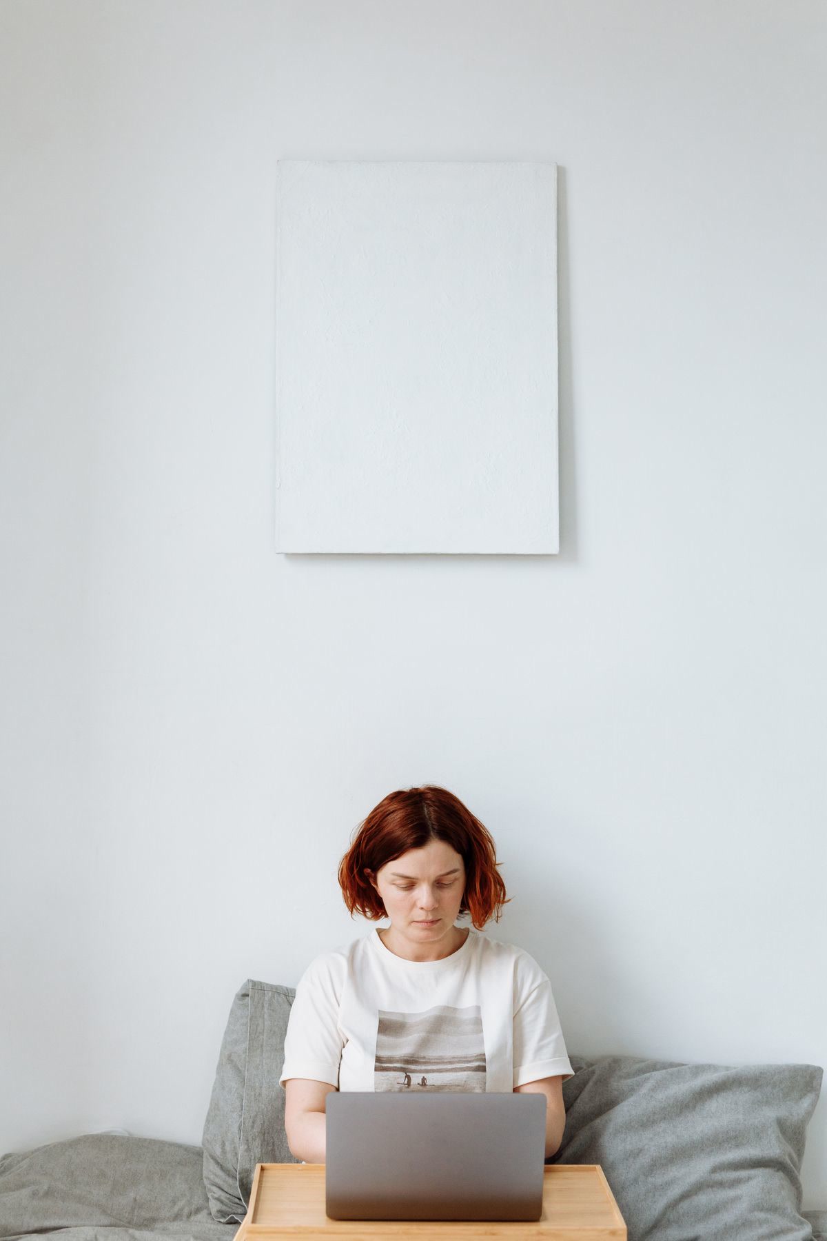Person working comfortably on a couch with a lap desk