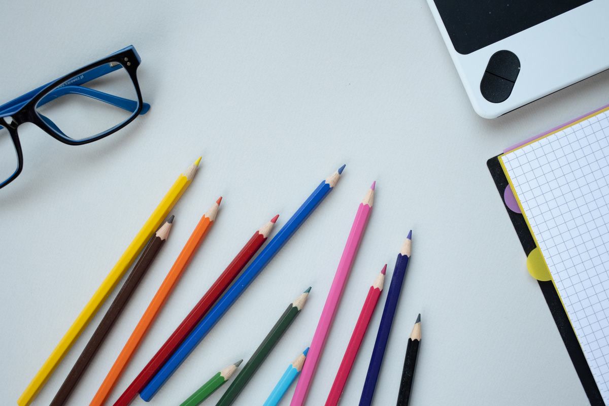 Colored pencils and art supplies arranged on a clean desk