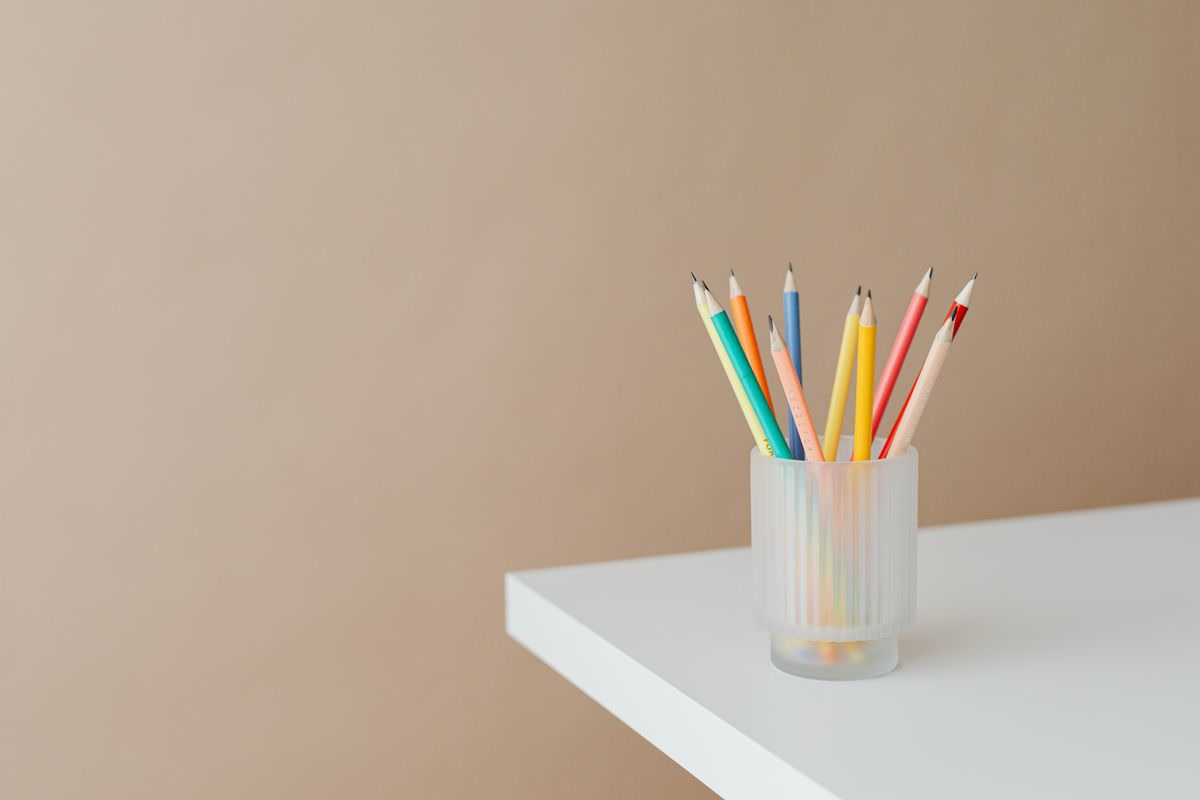 X-ACTO electric pencil sharpener on a desk next to freshly sharpened colored pencils