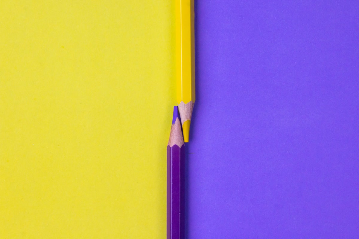 Three colored pencil sets side by side comparison on wooden surface