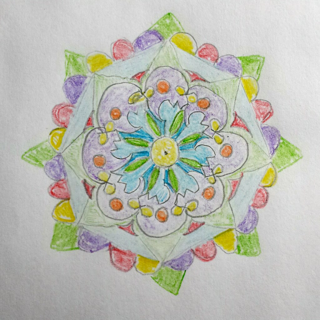 Finished zen tangle coloring page filled with vibrant jewel-toned colors in a complex geometric pattern, each small section a different rich color, professional and intricate result, colored pencils arranged nearby, warm studio lighting, flat lay photography, impressive meditative art