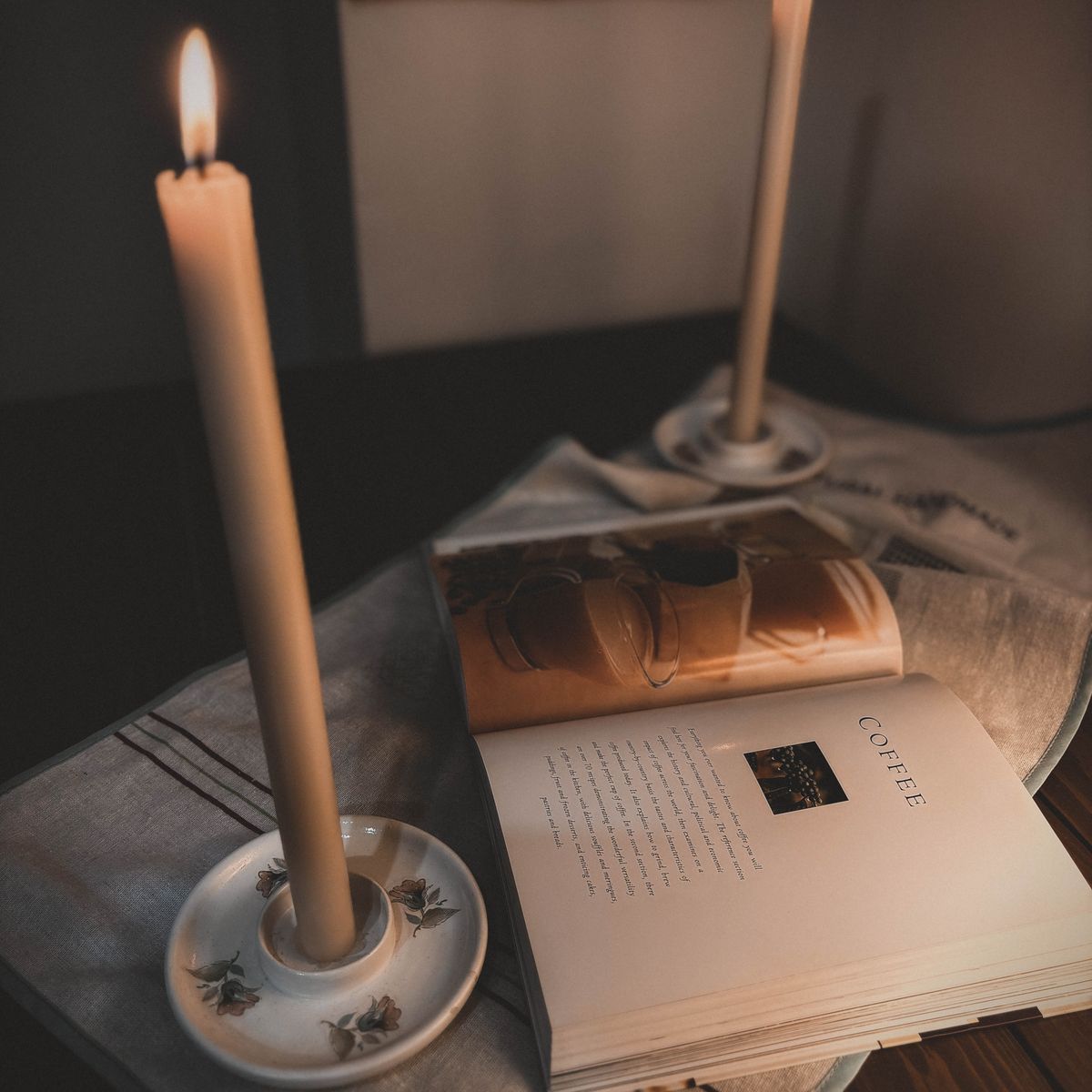 Cozy evening scene with candles and an open book on a table, warm ambient lighting for a peaceful bedtime routine