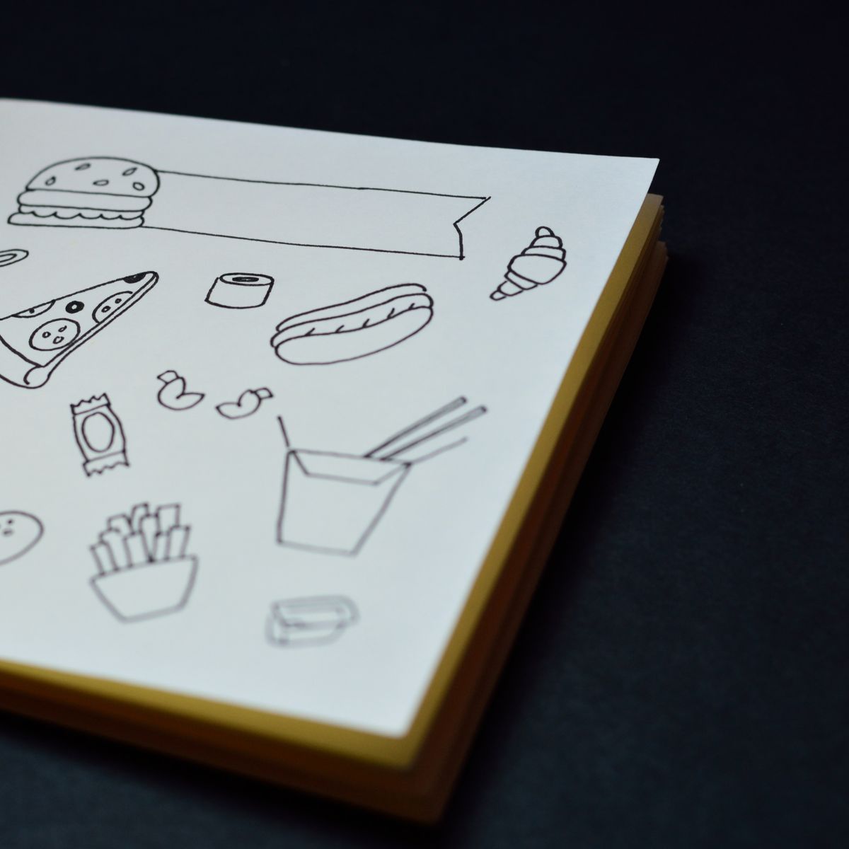 Open coloring book with line drawings on a desk, colored pencils ready for a coloring session